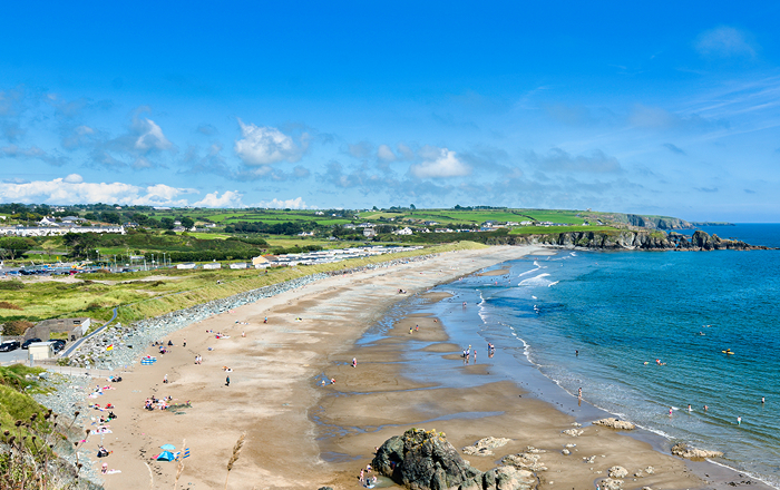 Wide sandy beach with blue ocean.