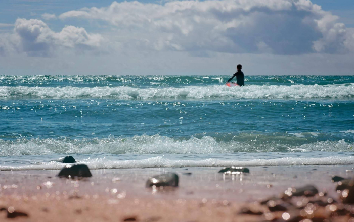 Person surfing in blue ocean waves.